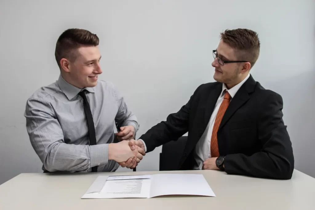 Two men shake hands over a business deal